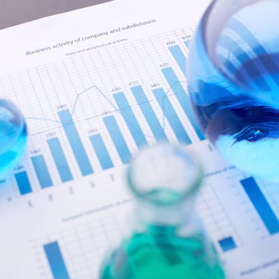 Chemical report Test-tubes with blue liquids over business document